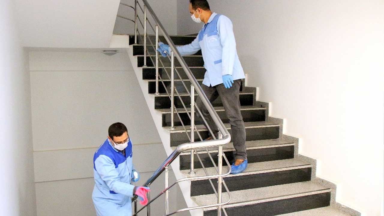 İki personel merdiven korkuluğunu siliyor